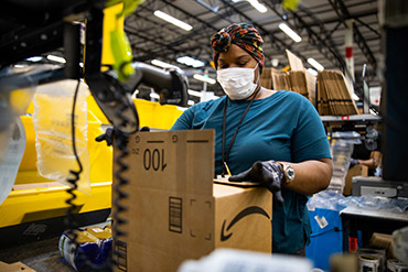 An Amazon associate wearing PPE in an Amazon warehouse